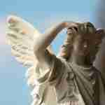 Un primer plano de un ángel de piedra blanca con alas y expresión serena, sobre un cielo azul con ligeras nubes, evoca a los Hijos de Dios de la Biblia.
