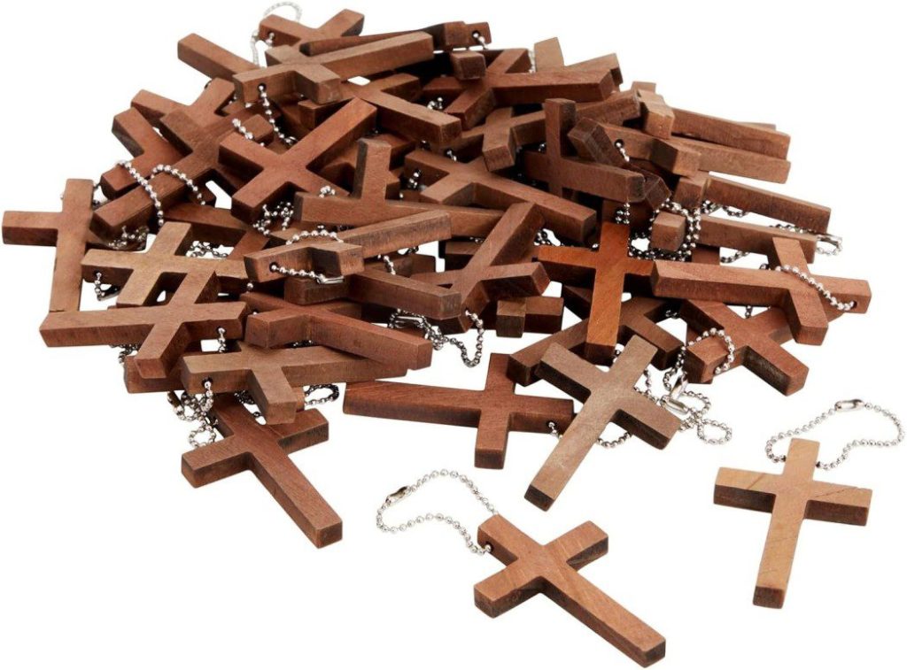 Una pila de collares de cruces de madera con cadenas de plata descansa elegantemente sobre un fondo blanco, perfecto como idea para regalar en un bautizo.