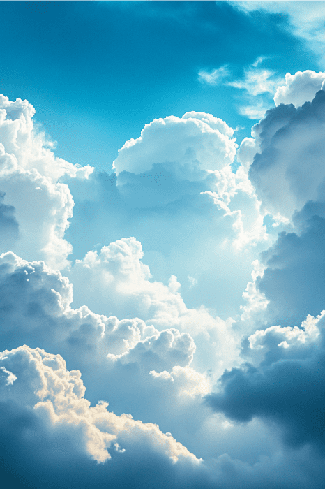 Unas nubes blancas y esponjosas sobre un cielo azul brillante, iluminadas por la luz del sol, recuerdan la paz tranquilizadora de las oraciones católicas contra la ansiedad y el estrés.