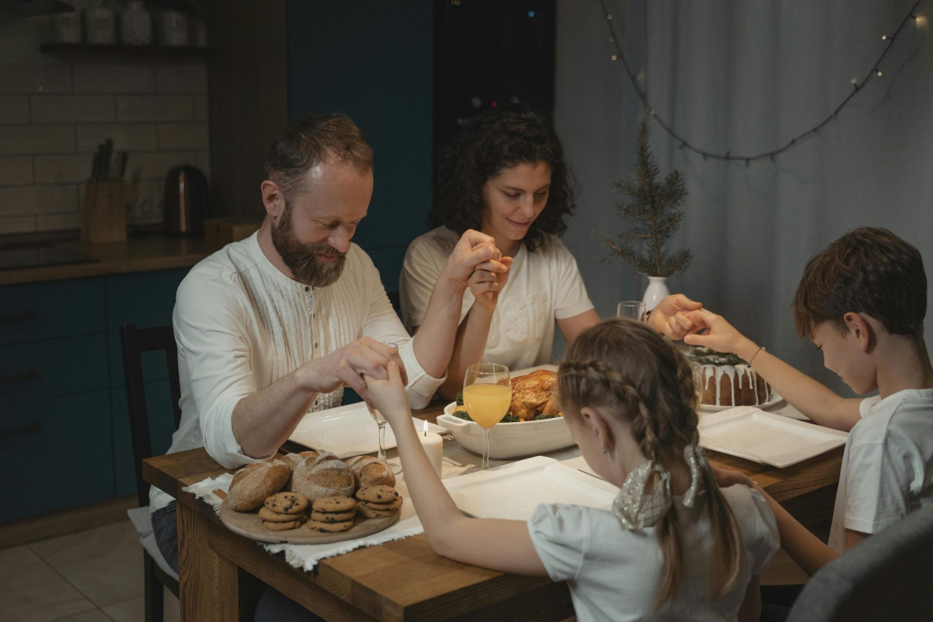 Una pareja cristiana y sus hijos rezan juntos.