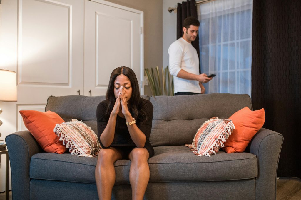 Una señora cuyo marido la engañó está sentada en un sofá. Matrimonio y divorcio