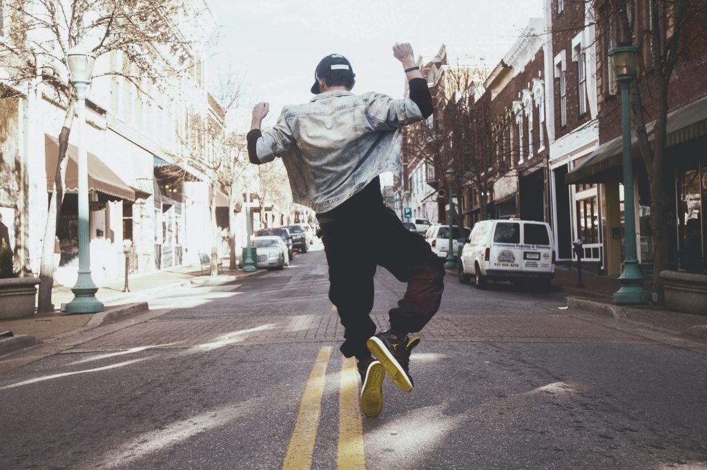 A man dances hiphop style in a street in the city. His freedom is showing dance in the Bible as worship of God.