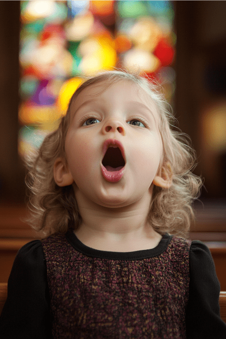 Un niño pequeño canta maravillosamente en una iglesia, las vibrantes vidrieras proyectan sombras de colores: una escena inspiradora en uno de los mejores nombres para las reuniones de la iglesia de los niños.