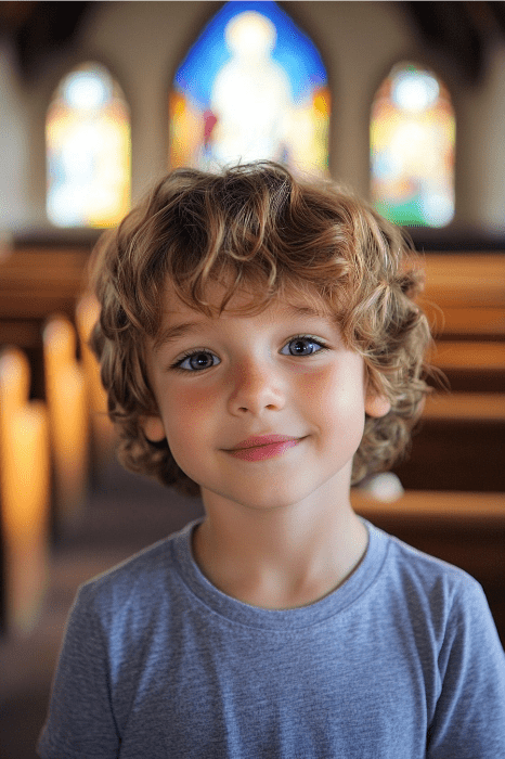 Un niño de pelo rizado resplandece de alegría en una iglesia infantil, rodeado de la vibrante elegancia de las vidrieras.