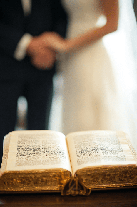 A couple holds hands at a wedding ceremony, with an open Bible in the foreground, reminiscent of KJV devotions for married couples.
