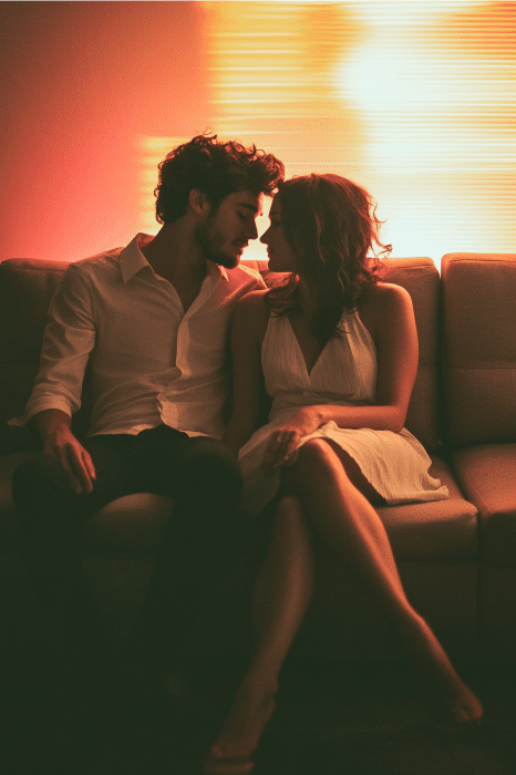 Sob a luz suave de um abajur, um casal senta-se no sofá, encontrando consolo nos olhos um do outro, refletindo sobre como curar um casamento desfeito com Deus.