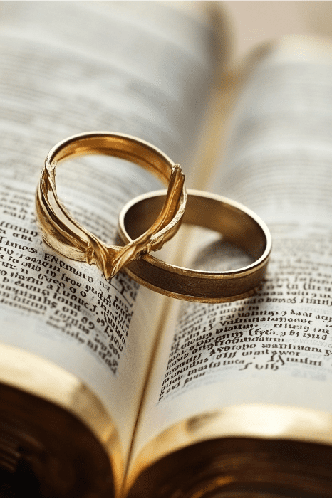 Duas alianças de ouro repousam elegantemente sobre um livro aberto, com as páginas sussurrando histórias de compromisso e união. Enquanto elas brilham à luz, pode-se refletir sobre quantas vezes o divórcio é mencionado na Bíblia, um testemunho da jornada duradoura do amor através do tempo.