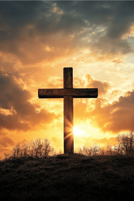 Una cruz de madera en una colina, silueteada contra una dramática puesta de sol y un cielo nublado, se alza como testamento silencioso de las reuniones en las que las rencillas familiares cuestionan que la iglesia se una en la reflexión y el compañerismo.