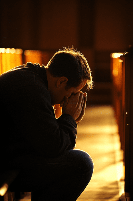 A man kneels in prayer, seeking guidance and blessings for church growth, in a quiet, sunlit sanctuary.