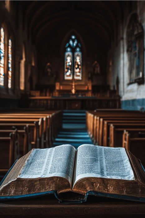 Un libro abierto descansa sobre un estrado en una iglesia poco iluminada, iluminado por el suave resplandor de las vidrieras, invitando a la contemplación y la reflexión, como si se preguntara: "¿Cuáles son las oraciones de AA?