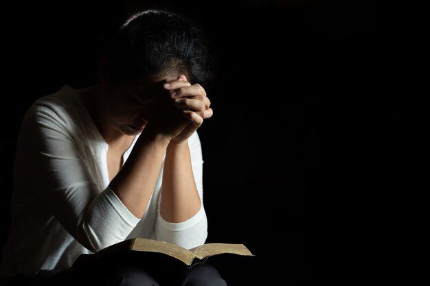 A woman praying to illustrate the point of prayer in Mothers Day messages for the church