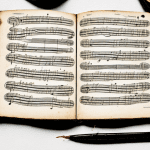 Libro de música de época con pluma y tintero