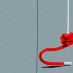 A city wall with a red rope hanging down from the top