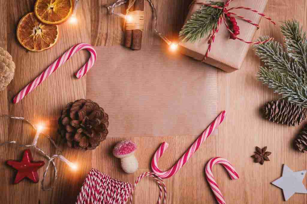 A mesa festiva é posta com bengalas doces, laranjas secas, pinhas, luzes de fada e presentes embrulhados - perfeita para uma atmosfera de aula da Escola Dominical de Natal.