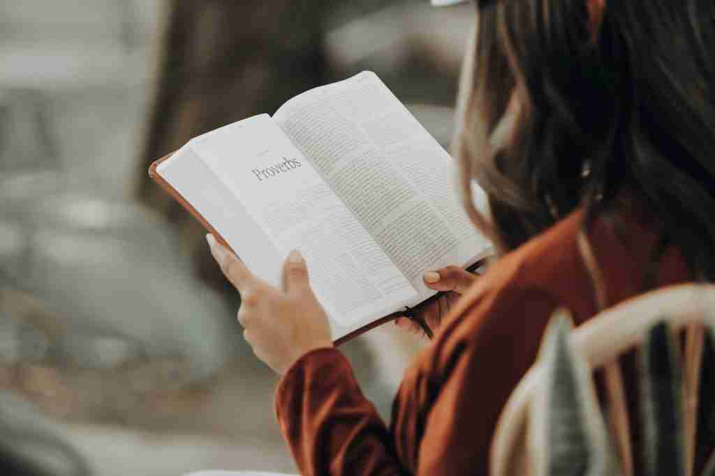 woman sitting reading bible verse to pray for church leaders