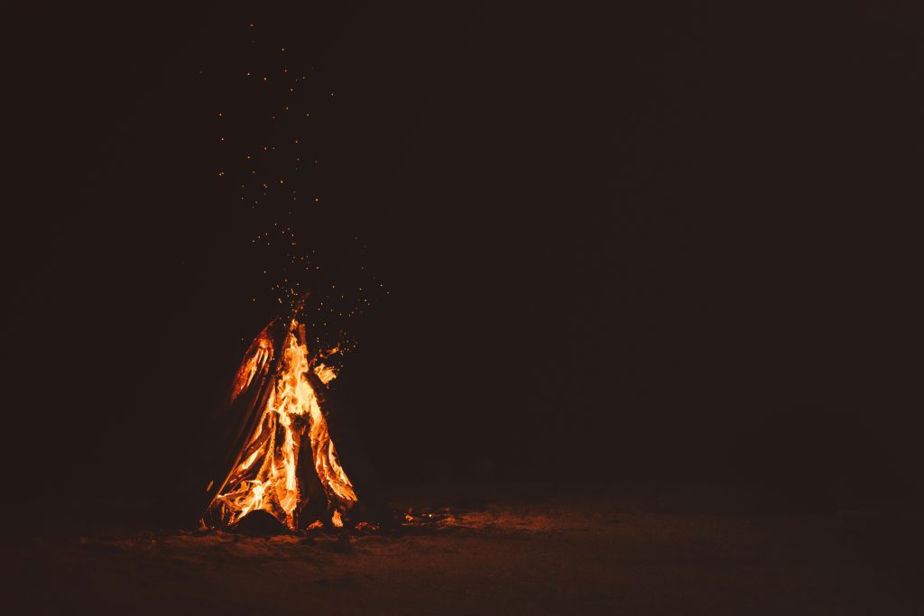 A fire burns in the dark night, signifying fire in the Bible