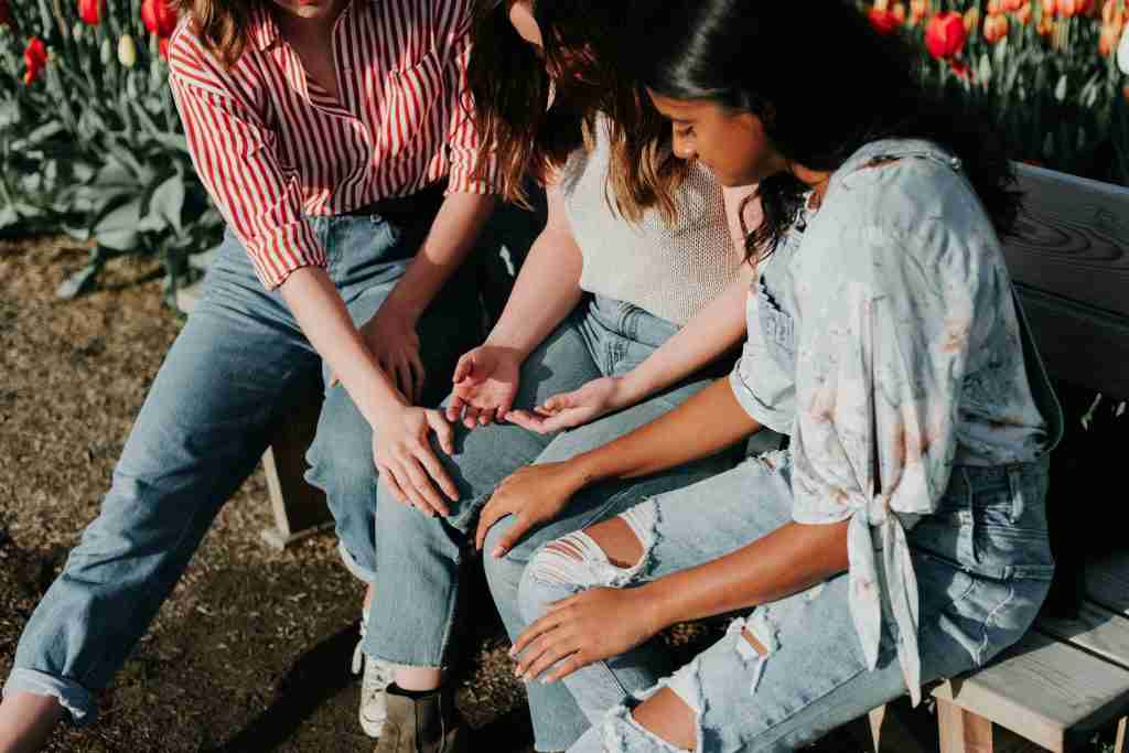 three women praying in discipleship meeting at church