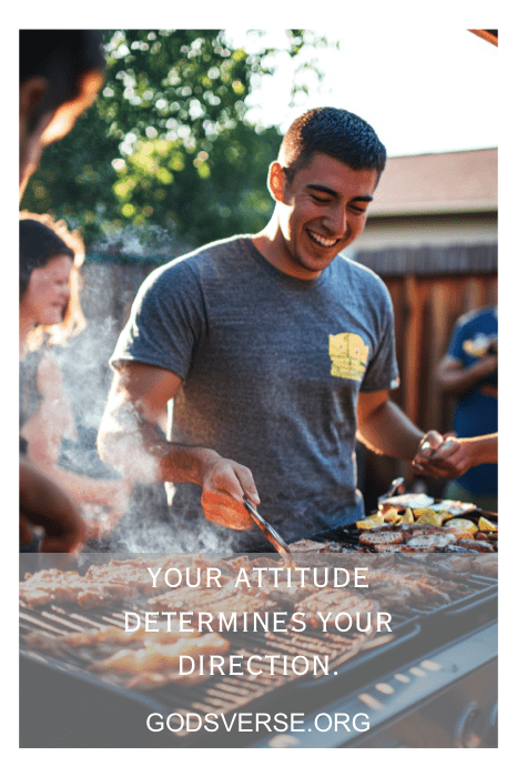 Hombre sonriendo mientras cocina en una parrilla; texto: "Tu actitud determina tu dirección. Acéptala con estas frases de actitud para hombres. Godsverse.org.