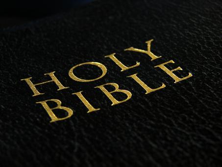 Holy Bible written against a dark surface assumed to be a Bible