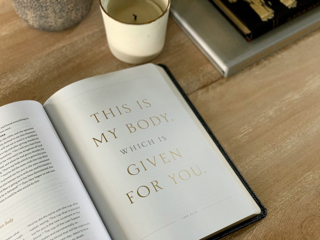 A Bible laying open with the words 'This is my body which is given for you' showing why jesus had to come to earth