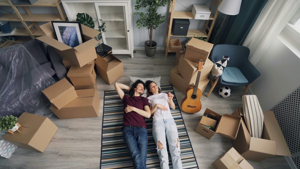A man and woman lays between moving boxes. He finds a wife who is his partner, like the scripture suggests.