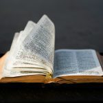 Quantas vezes a expressão "não temas" é mencionada na Bíblia? Um livro aberto com páginas viradas, em um fundo escuro, evoca os profundos mistérios em seu interior, convidando à reflexão sobre temas como a quantidade de vezes que "Fear Not" aparece na Bíblia.
