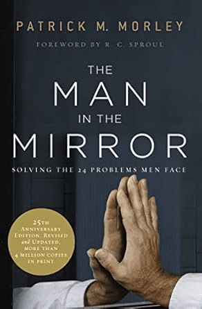 The book cover of "The Man in the Mirror" by Patrick M. Morley, ranked among the Best Bible Studies for Men, features hands clasped in prayer beneath a compelling title and text overlay.