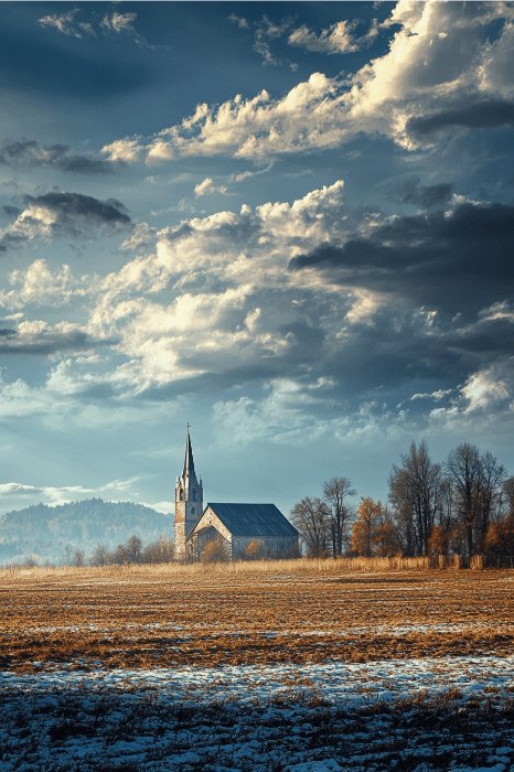 Uma igreja rural com uma alta torre fica sob um céu nublado dramático, cercada por campos e colinas distantes, servindo como um lembrete sereno dos versículos bíblicos sobre força mental.