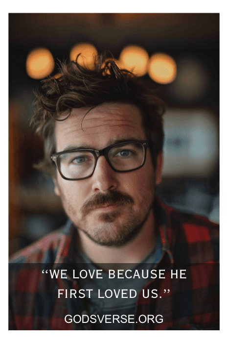 Um homem de óculos olha para a câmera; o texto sobreposto diz "Nós amamos porque Ele nos amou primeiro", "GODSVERSE.ORG" e "Inspiring Bible Verses About Husbands".