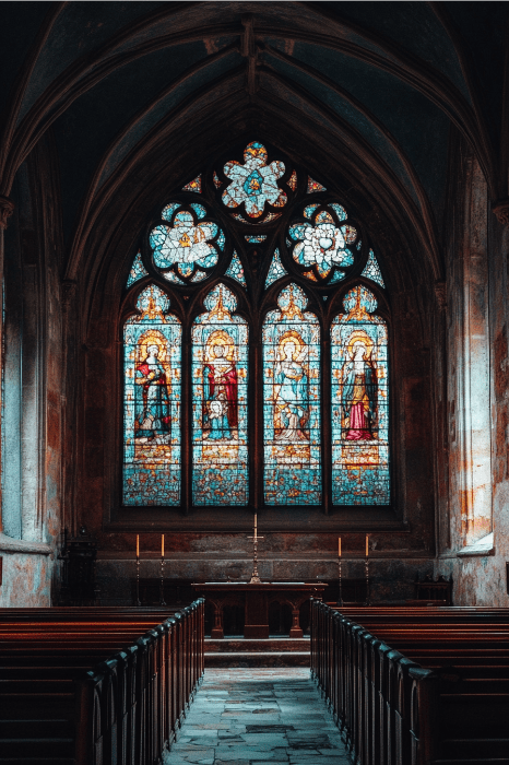 O interior da igreja, com seus vitrais ornamentados e bancos de madeira, oferece um ambiente sereno para qualquer ideia de série de sermão de Páscoa.