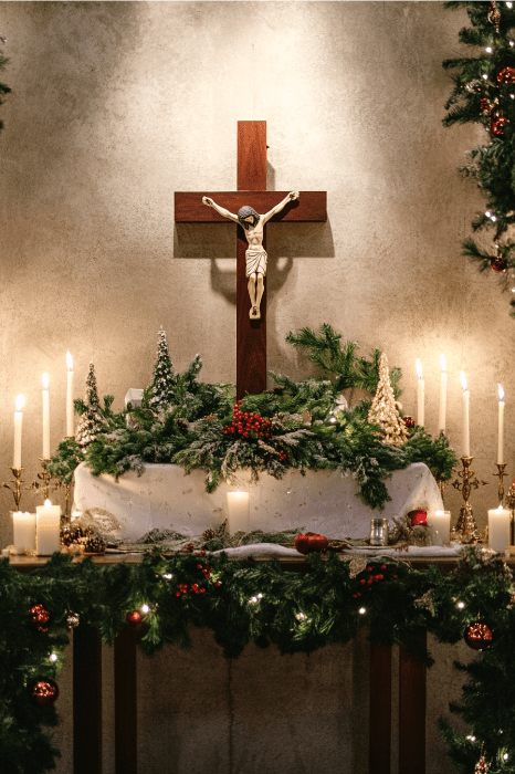 A decorated altar with a crucifix, surrounded by candles, greenery, and festive decorations, presents a peaceful setting that invites contemplation. For those seeking valid reasons for changing churches, this serene atmosphere might offer the clarity and comfort needed for such a pivotal decision.