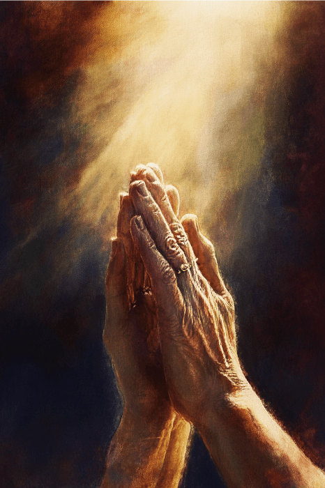 Aged hands clasped in prayer under a beam of light against a dark background, echoing the solace found in bible verses to comfort a grieving mother.