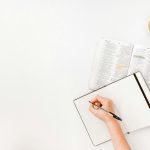 Discover How Many Chapters There Are in the Bible Jotting down thoughts in a notebook, surrounded by the open pages of an enlightening book and a steaming coffee cup on the white table, perhaps pondering questions like how many chapters are in the Bible.
