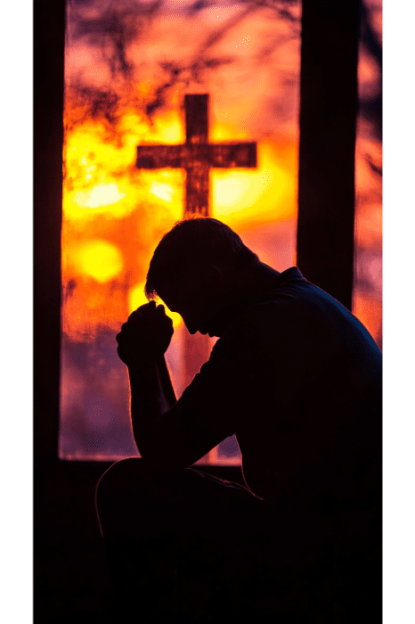 Silueta de una persona ofreciendo oraciones de perdón junto a una ventana con una cruz y una vibrante puesta de sol de fondo.